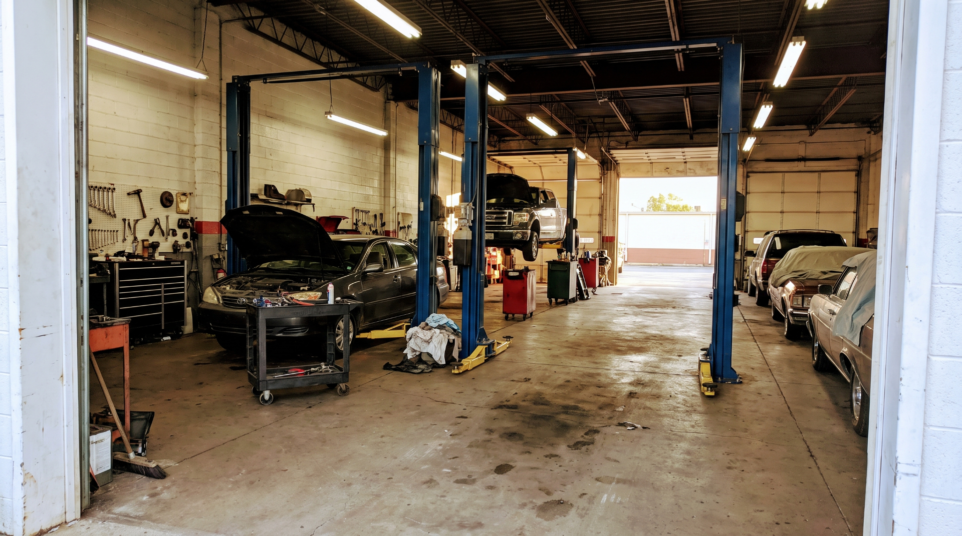 Interior of a multi-bay automotive service shop with two-post lifts
