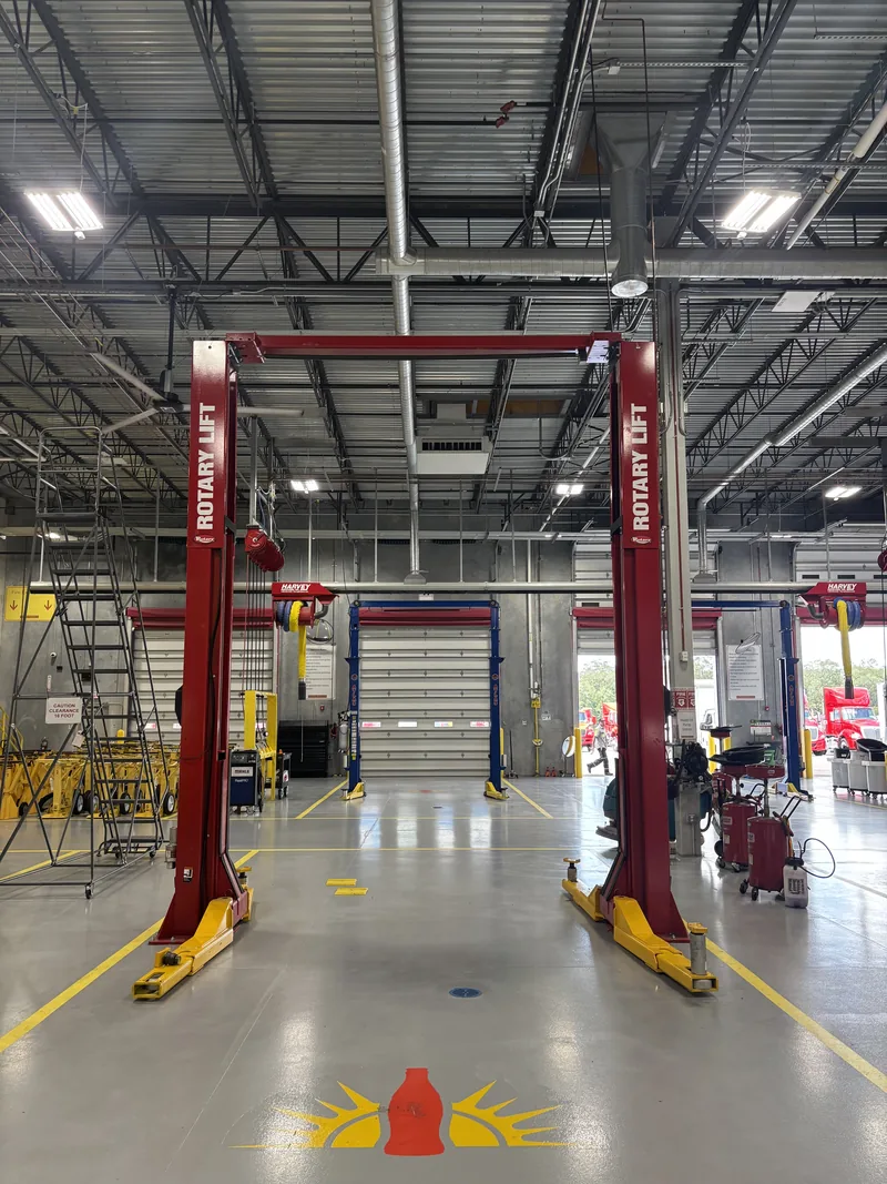 Rotary two-post lift in a service bay
